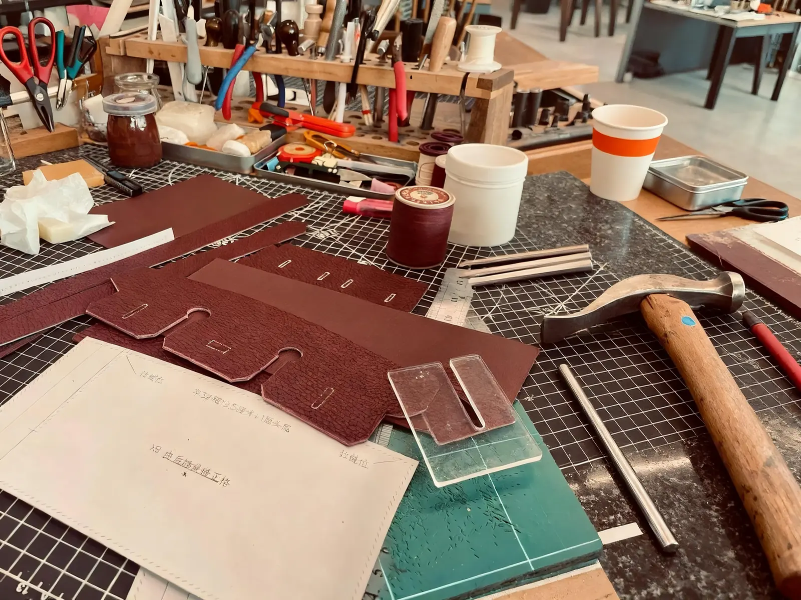 Exceptional leather, traditional tools and hand-cut pattern pieces on a Lone Cuir artisan workbench